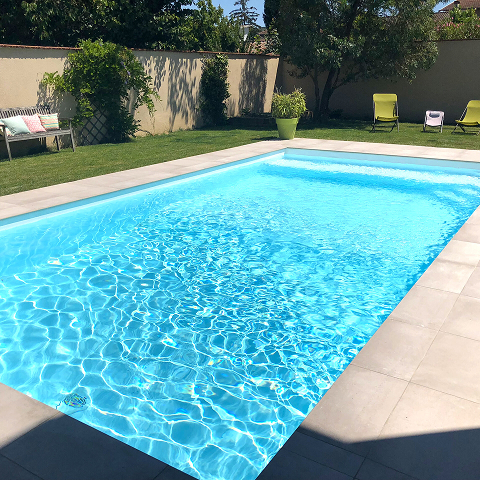Piscine rectangulaire avec margelles en pierre claire